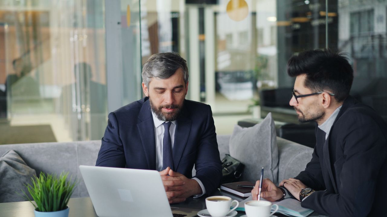 Two businessmen in suits discussing work